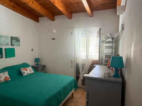 a bedroom with a green bed and a window at Home Music & Love in Favignana