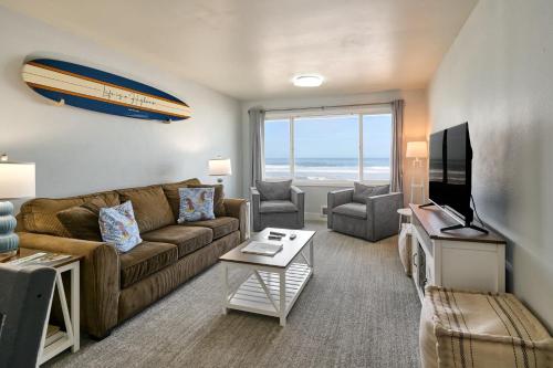 a living room with a couch and a television at Oceanfront Suite - Upper Floor in Lincoln City