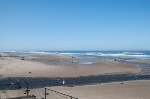 a group of people walking on the beach at Oceanfront Suite - Upper Floor in Lincoln City