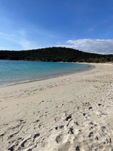 a beach with footprints in the sand and the ocean at Apartment Su Cramu in Villacidro