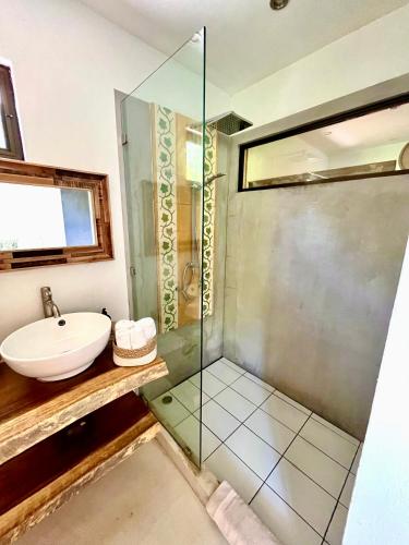 a bathroom with a glass shower and a sink at Hotel El Manglar in Playa Grande