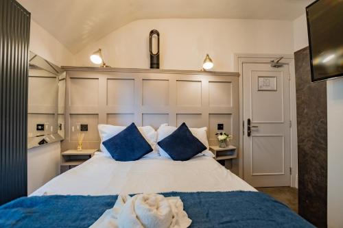a bedroom with a large bed with blue pillows at Modern Studio by the Marina in Dublin