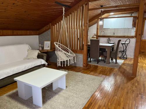 a living room with a hammock and a dining room at Apartman Vana in Vrnjačka Banja