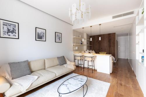 un salon avec un canapé blanc et une cuisine dans l'établissement Le Miramar Apartment Sea View, à Cannes