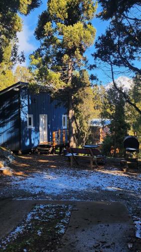 a blue shed with a picnic table in front of it at Cabaña monoambiente en Bariloche 3 pax in San Carlos de Bariloche