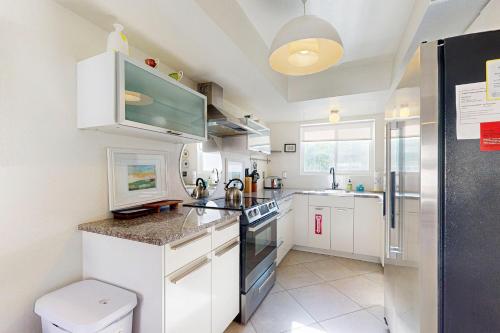 a white kitchen with a sink and a stove at Oakmount Escape in Desert Hot Springs