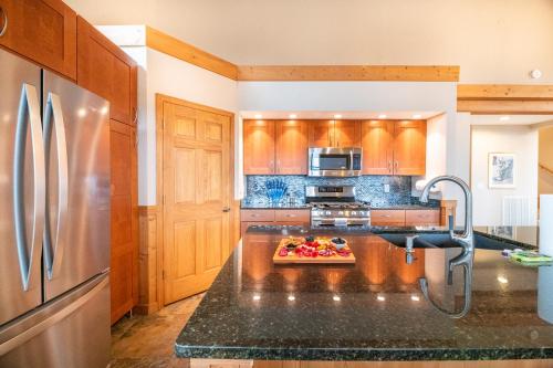 a kitchen with a refrigerator and a black counter top at Kodak Moments By Avada Properties in Kodak