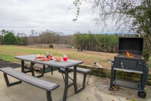 a picnic table and a grill with a table and a fire at Kodak Moments By Avada Properties in Kodak