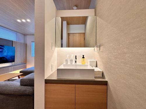 a bathroom with a sink and a mirror at Aoi Suite Takayama - Vacation STAY 15104v in Takayama