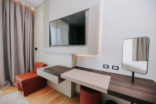 a small room with a table and a mirror at Magnus Hotel in Vlorë