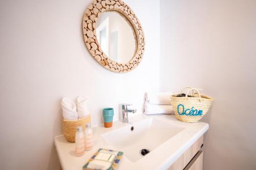 a bathroom with a sink and a mirror on the wall at Ocean By La Siredrah in Wassane