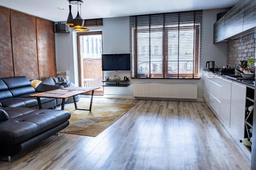 a living room with a couch and a table at Loft Świetego Mikołaja - Blisko Rynku - Klimatyzacja in Wrocław
