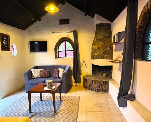 a living room with a blue couch and a fireplace at Rancho EL PARAÍSO AJUSCO in Mexico City