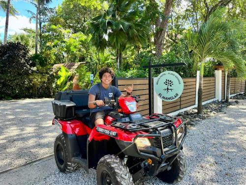 a man sitting on a four wheeler vehicle at Hotel El Manglar in Playa Grande