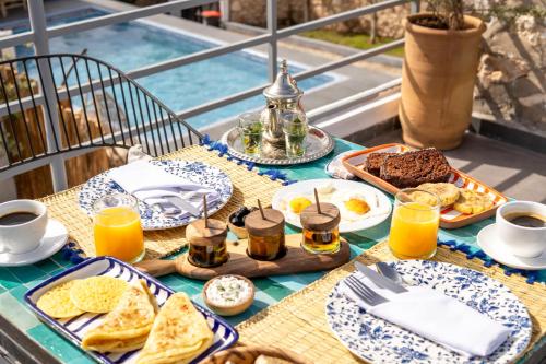 a breakfast table with breakfast foods and orange juice at Ocean By La Siredrah in Wassane
