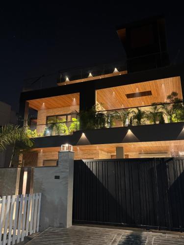 a house with a black fence and a white picket fence at Skywood Villa Rooms in Lucknow