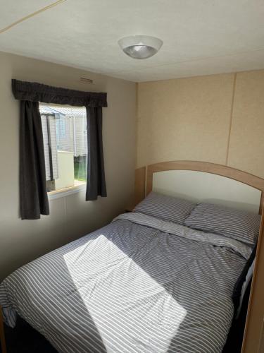 a bed in a small room with a window at ABI Vista Caravan, Whitley Bay in Whitley Bay