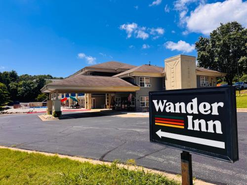 a sign in front of a building with a yard inn at Wander Inn in Branson