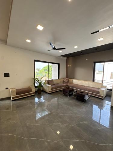 a large living room with couches and a ceiling fan at Skywood Villa Rooms in Lucknow