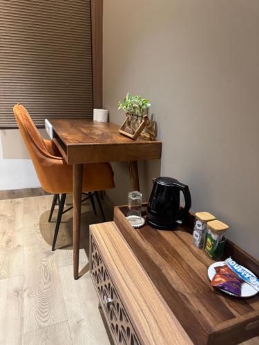 a table and a chair with a tea kettle on it at Skywood Villa Rooms in Lucknow