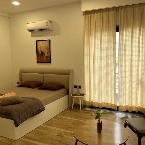 a bedroom with a bed and a table in it at Skywood Villa Rooms in Lucknow
