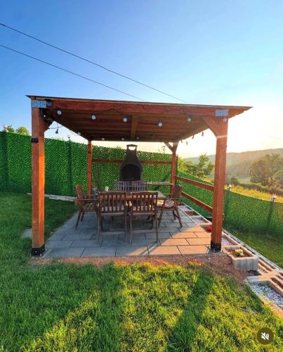 a wooden pergola with a table and chairs on a patio at Villa Roi in Ferizaj