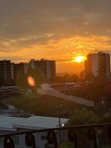 a sunset in a city with buildings in the background at Nice and confortable 2 bedrooms apartment in Escazu in San Antonio