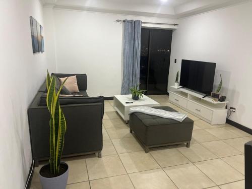 a living room with a couch and a tv at Nice and confortable 2 bedrooms apartment in Escazu in San Antonio