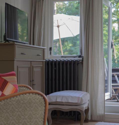 a living room with a radiator and a window with a windmill at Bed, Boom en Droom in Rolde