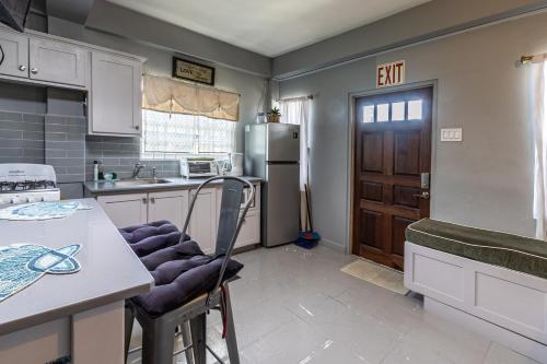 a kitchen with a refrigerator and a table and chairs at Modern Apartment near Pigeon Point with Breakfast in Bon Accord