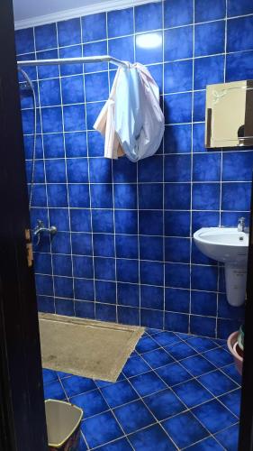 a blue tiled bathroom with a toilet and a sink at PORTO MATROUH chalet families only in Marsa Matruh