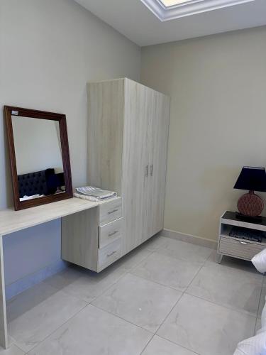 a room with a mirror and a dresser with a mirror at قمم الخضراء 