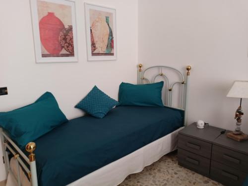 a bedroom with a bed with blue pillows and a nightstand at Mura di prati in Rome