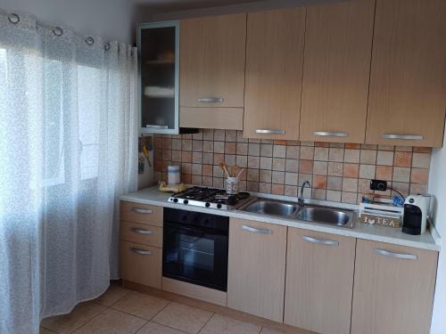 a kitchen with a sink and a stove at Confort home in Rende