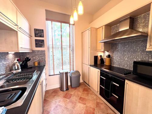 a kitchen with a sink and a stove top oven at Fabulous 2 bed Historic Ground floor apartment Belper with free car parking next to property in Belper