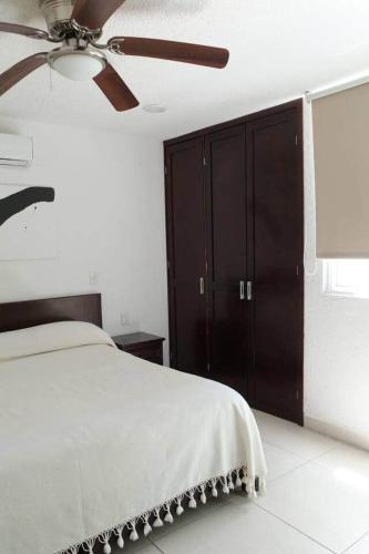 a bedroom with a bed and a ceiling fan at Las Gaviotas Hotel and Suites in Cancún