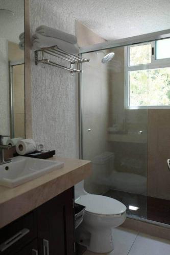 a bathroom with a toilet and a sink and a shower at Las Gaviotas Hotel and Suites in Cancún