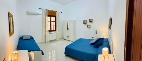 a bedroom with a blue bed and a window at Da Liliana Apartment in Mazara del Vallo