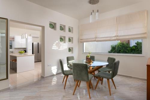 a kitchen and dining room with a table and chairs at Excelencia New Villa with Artistic Pool & Sea View in Asgourou