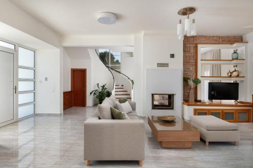 a living room with a couch and a table at Excelencia New Villa with Artistic Pool & Sea View in Asgourou