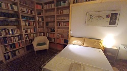 a room with a bed in a library with book shelves at Casa Braglia in Modena