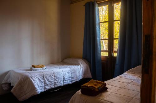 a room with two beds and a window at Cabaña Finca La Micela - Tupungato in Tupungato