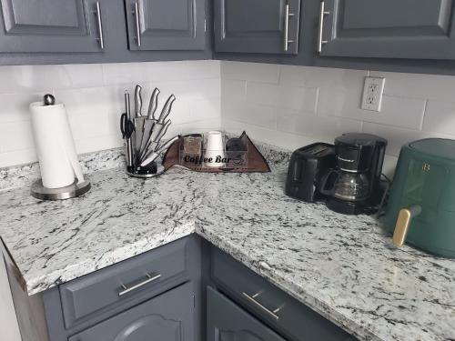 a kitchen counter top with a coffee maker and utensils at Spacious 4BR near NYC with Parking, 10min MetLife, 20min Times Sq in North Bergen