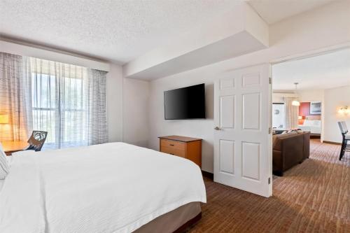 a hotel room with a bed and a flat screen tv at Sonesta ES Suites Phoenix Goodyear in Goodyear