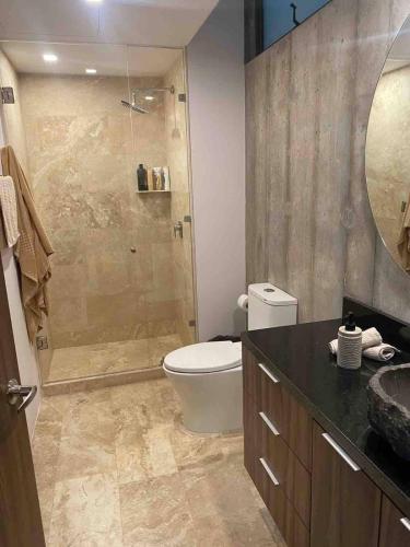 a bathroom with a shower and a toilet and a sink at Eco chic apartment in Tulum in Tulum
