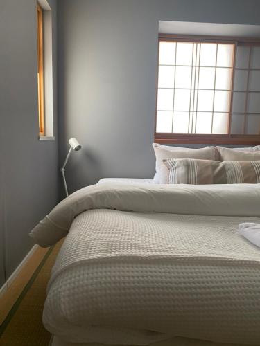 una camera da letto con due letti e una finestra di Myoko Forest Lodge a Myoko