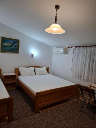 ein Schlafzimmer mit einem großen Bett und einer Lampe in der Unterkunft Aleksandrija in Čanj