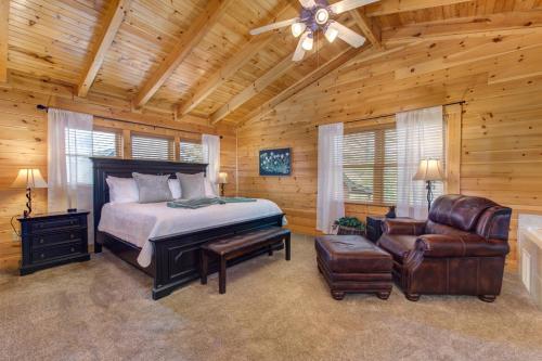 a bedroom with a bed and a chair and a ceiling fan at Blackberry Lodge By Avada Properties in Sevierville