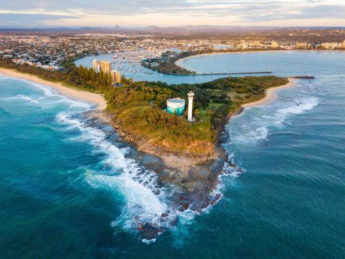an island in the ocean with a lighthouse on it at Big family holiday by the Buddina beach in Buddina