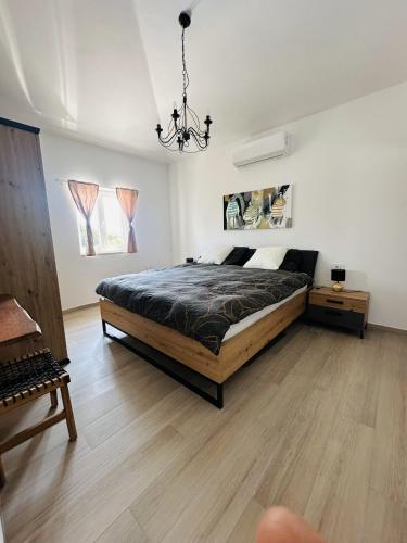 a bedroom with a large bed and a chandelier at Villa V in Svetvinčenat